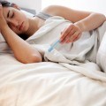 Woman Checking Her Temperature in Bed