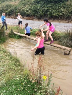 Girls crossing a log